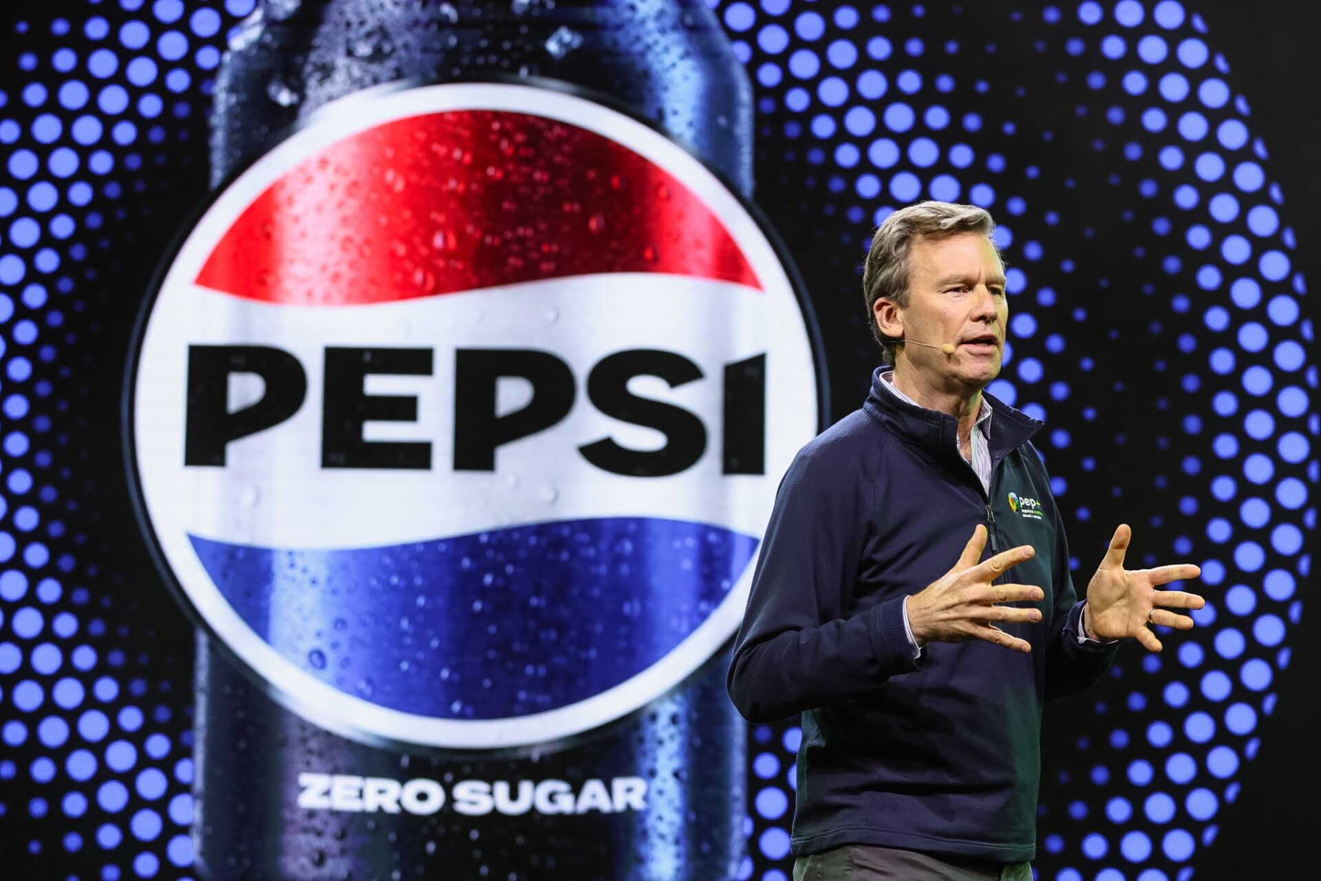 Джим Эндрю ведет презентацию на фоне изображения банки Pepsi